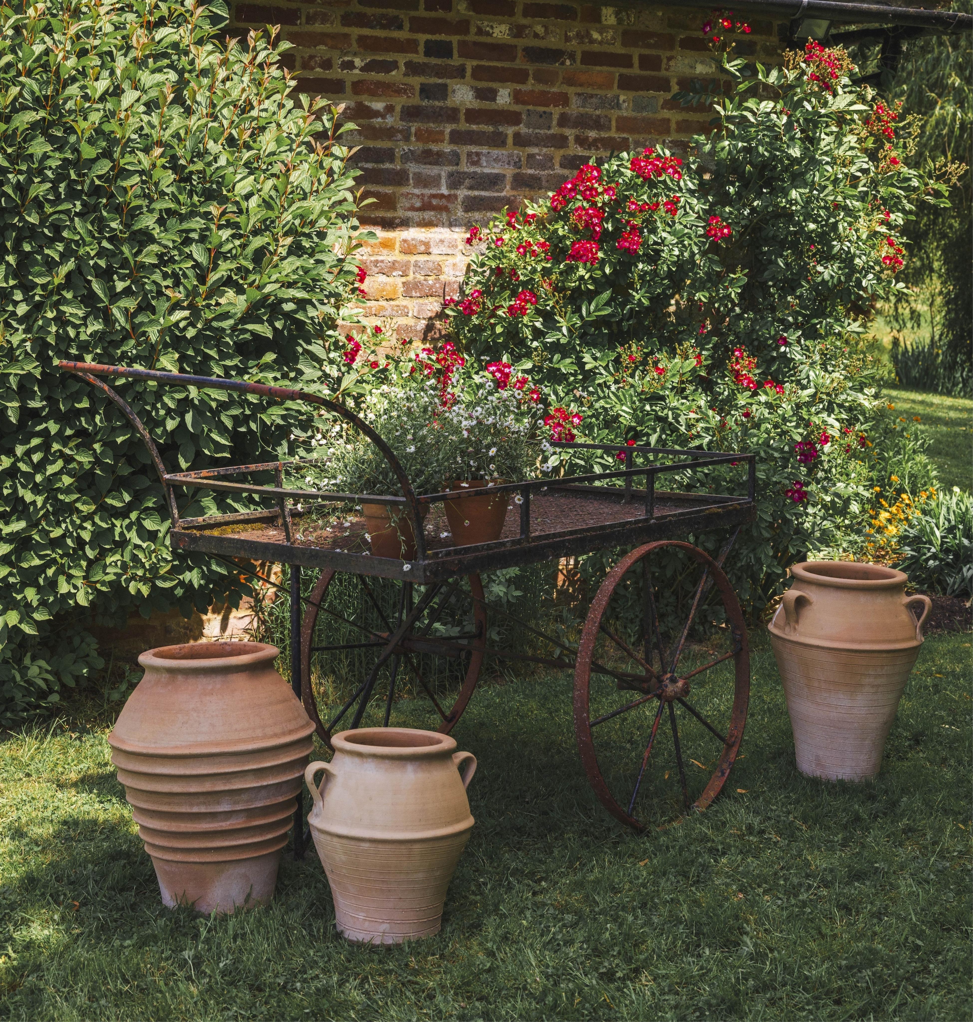 A wrought iron garden barrow, width 76cm, length 152cm, height 106cm
